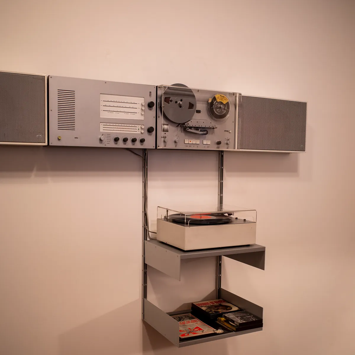 A Braun hi-fi system and record player mounted on a pale wall.