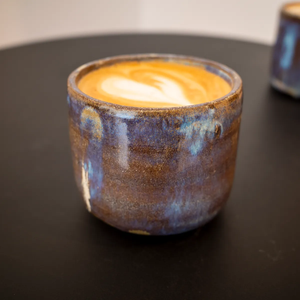 A flat white in a glazed ceramic cup.