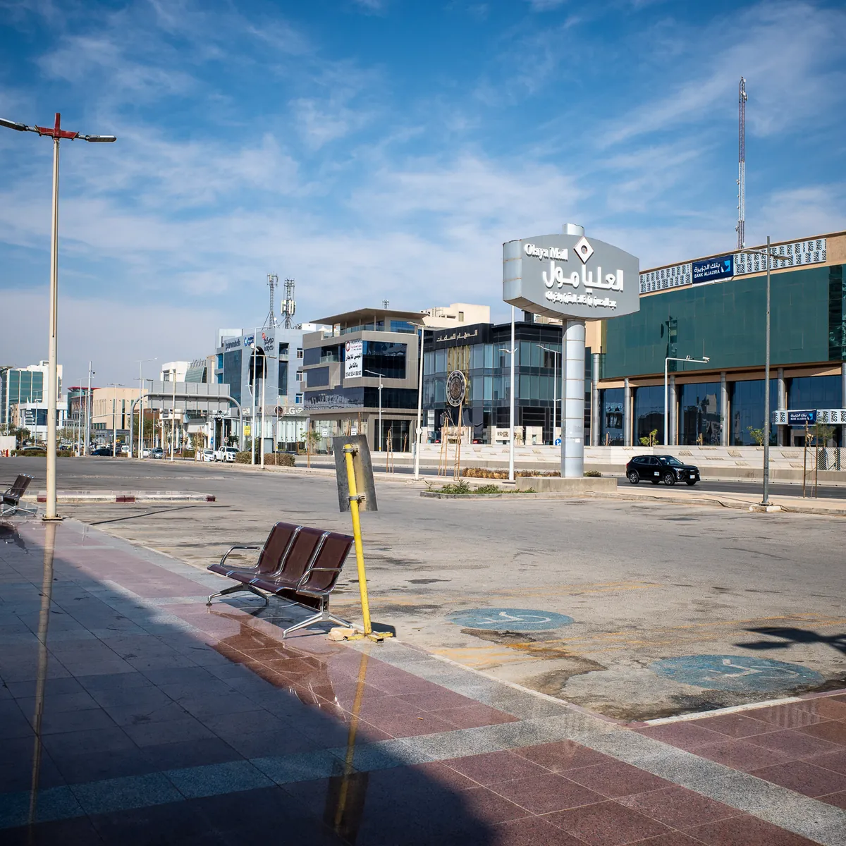 A wide, empty street between new office buildings under a blue sky.