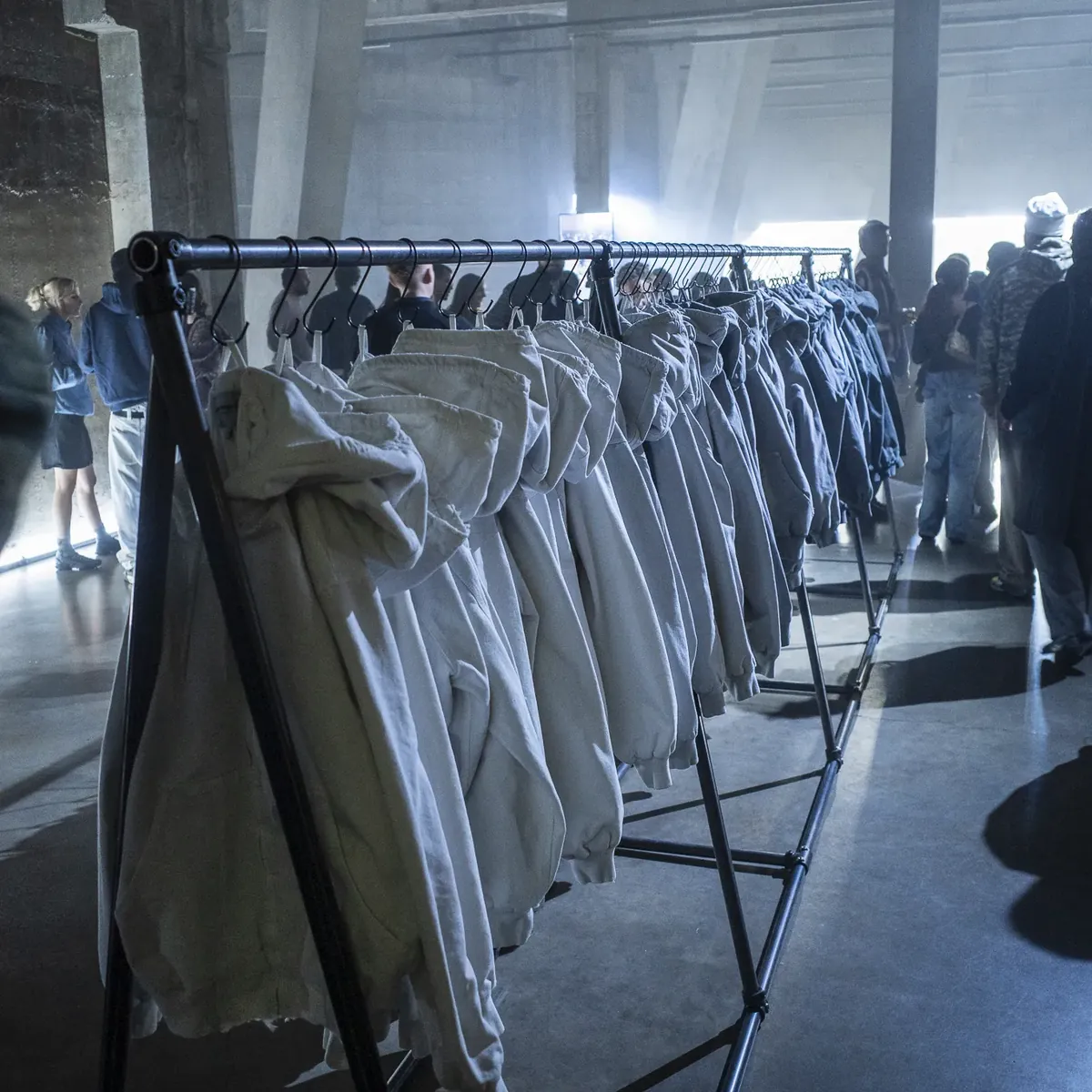 A rail of pale hooded Active Jackets in the raw concrete hall of Tate Modern.