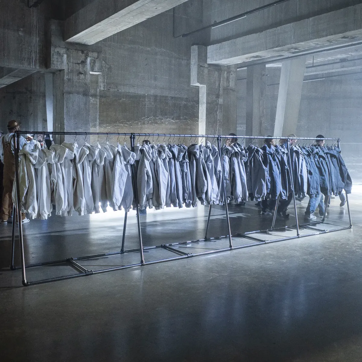 A long row of jackets in the haze of the Tanks at Tate Modern.
